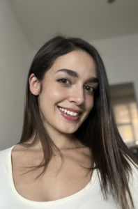 A woman with brown hair, smiling. 